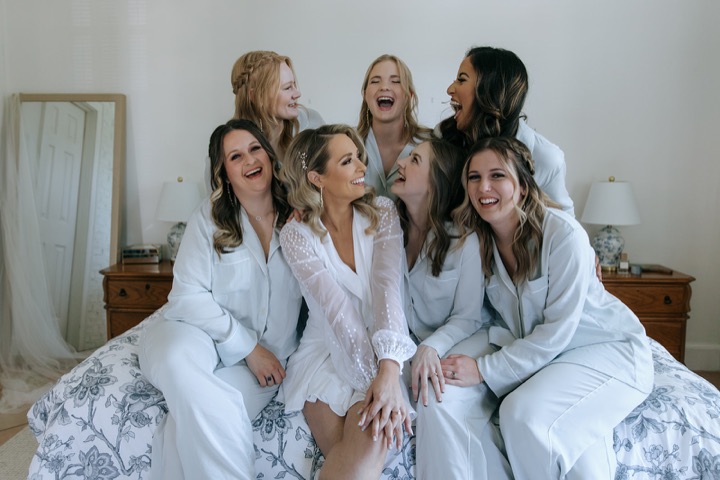 The bridal party laughing together in the blue toile bedroom