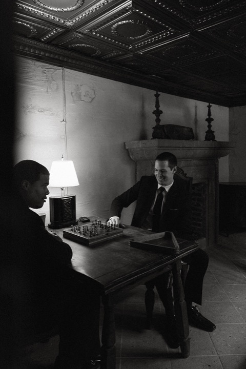 A black-and-white portrait of John at the chess table