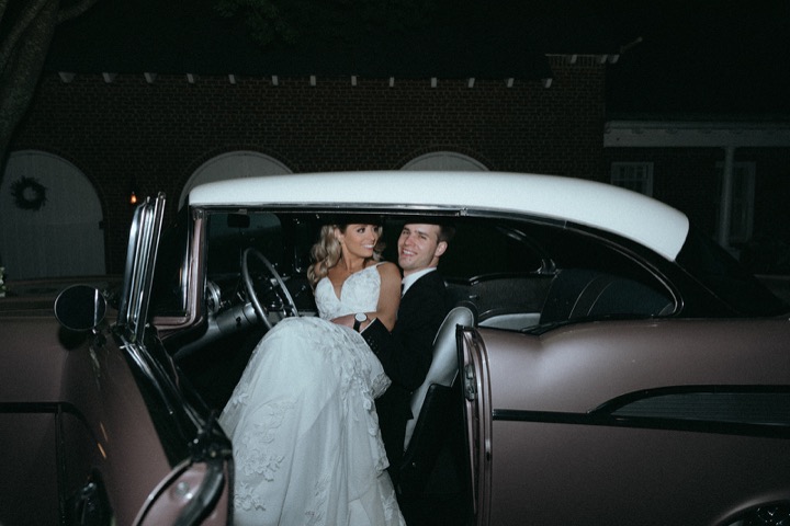 Taylor and John together in a vintage car