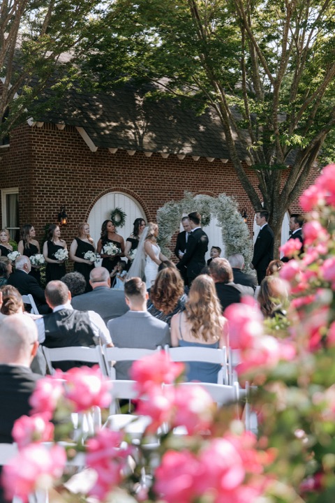 A view of the garden ceremony through pink flowers