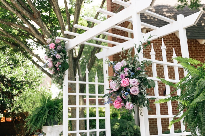 Pink flowers and white hanging decorations at the garden arbor