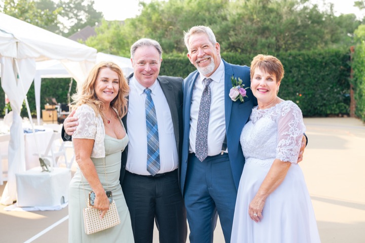 Dave and Leslie posing with guests beside the reception tent