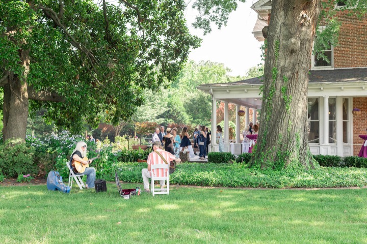 Guests relaxing on the lawn beneath the old oak