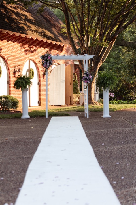 The wedding arbor lit up beside the Carriage House at night