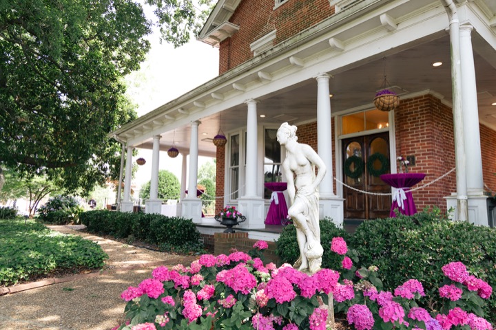 Pink flowers lining the Manor’s white-columned porch