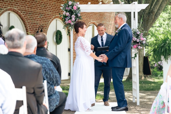 Dave and Leslie exchanging vows beneath the arbor