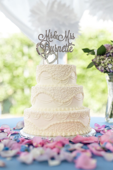 The wedding cake surrounded by pink and purple flowers
