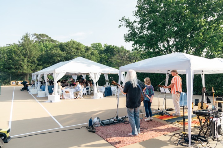 White reception tents set up beside the gardens
