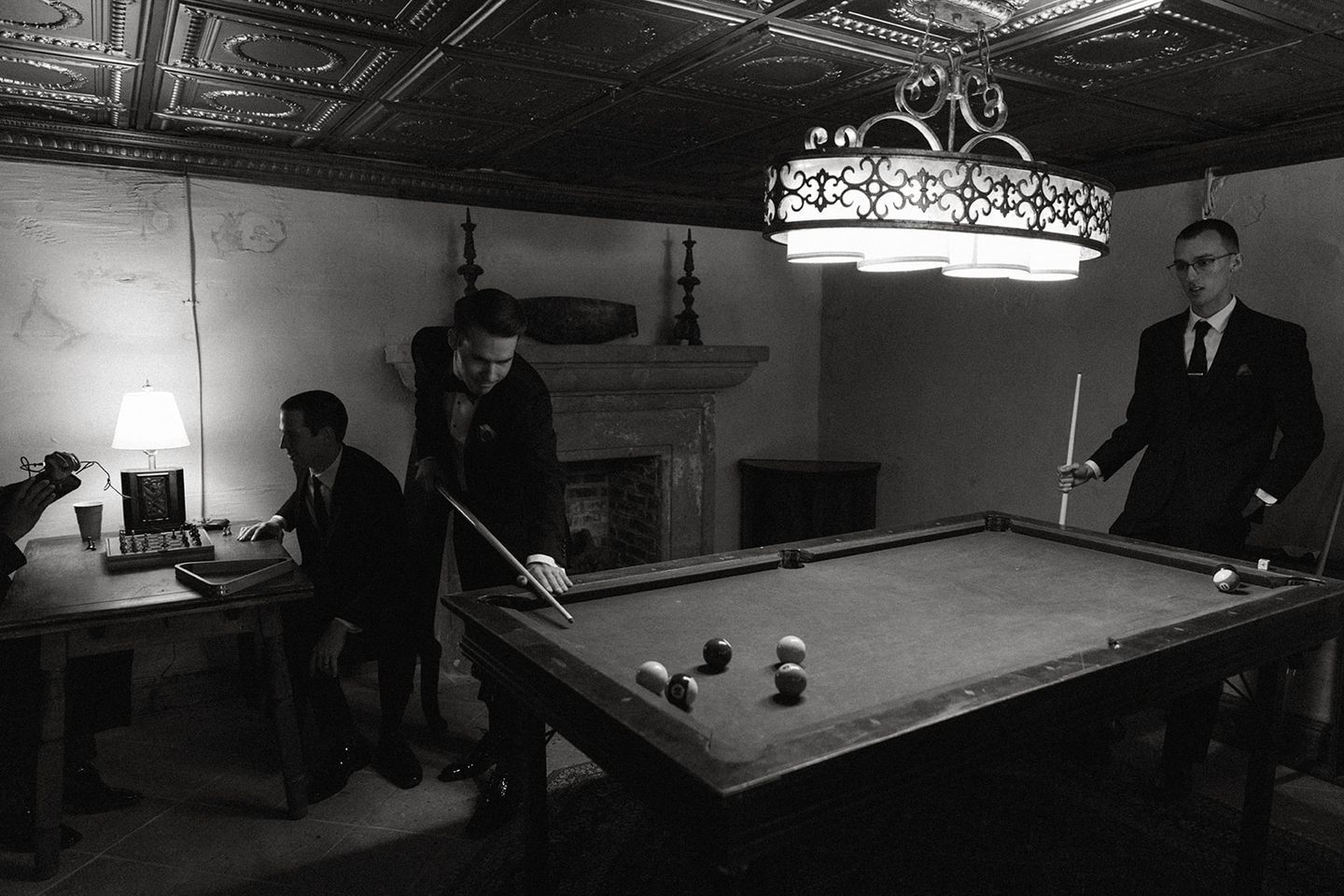 The groom and friends playing billiards in the antique-furnished Cellars