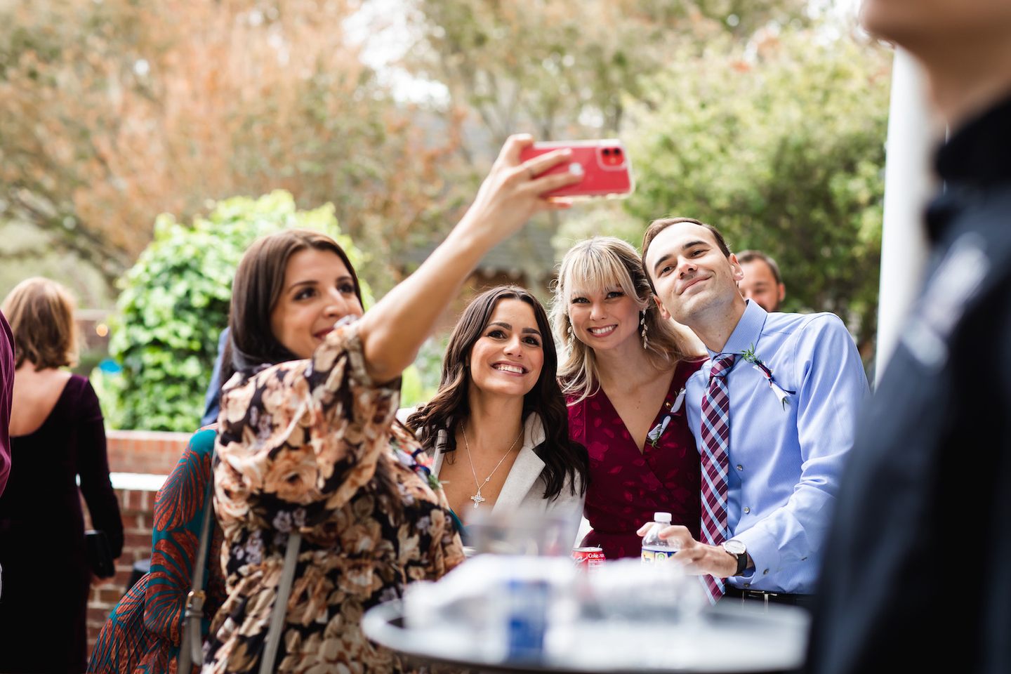 Wedding guests smiling together for a photograph during outdoor cocktail hour