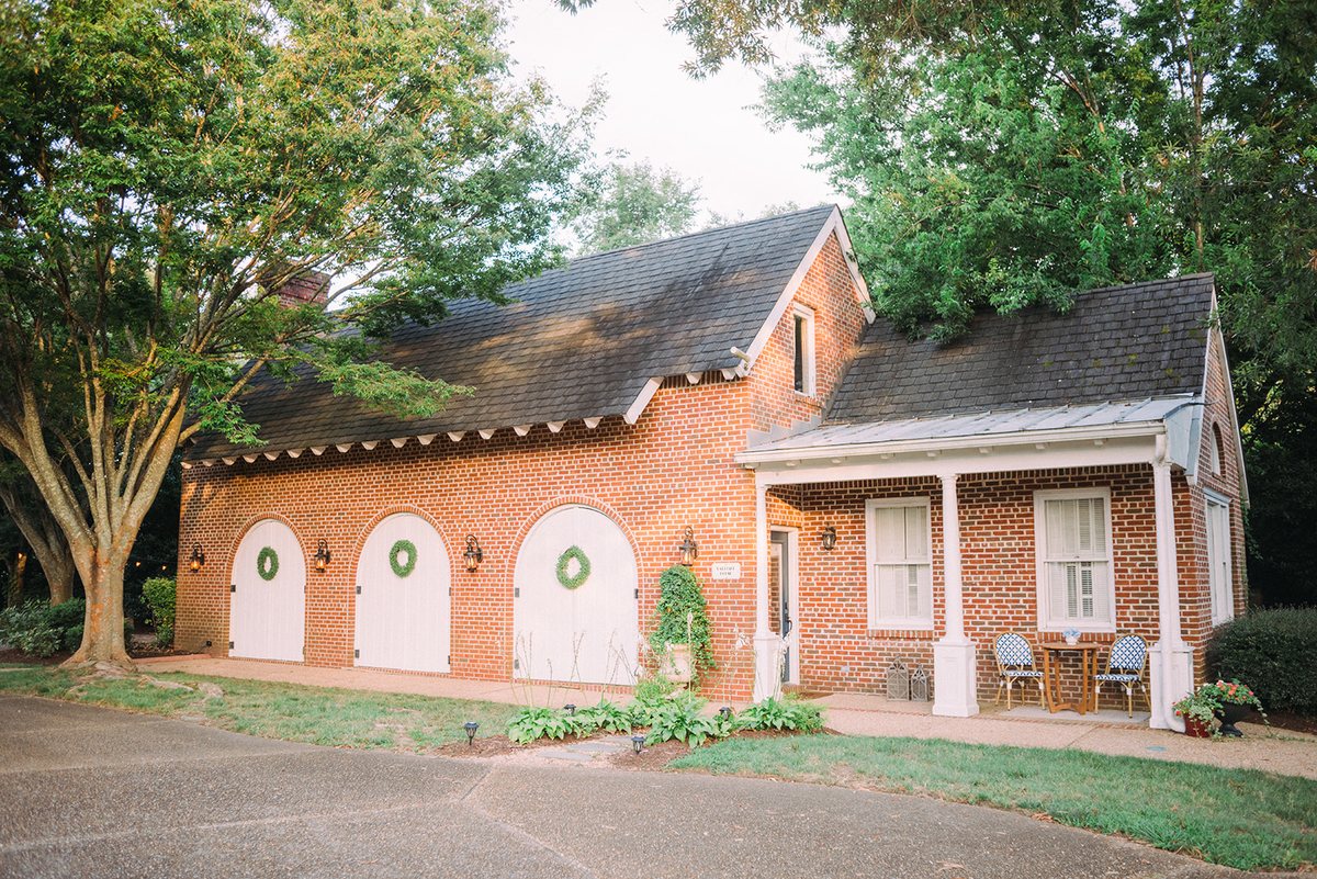 The brick Carriage House with its three white arched carriage doors and surrounding lawns