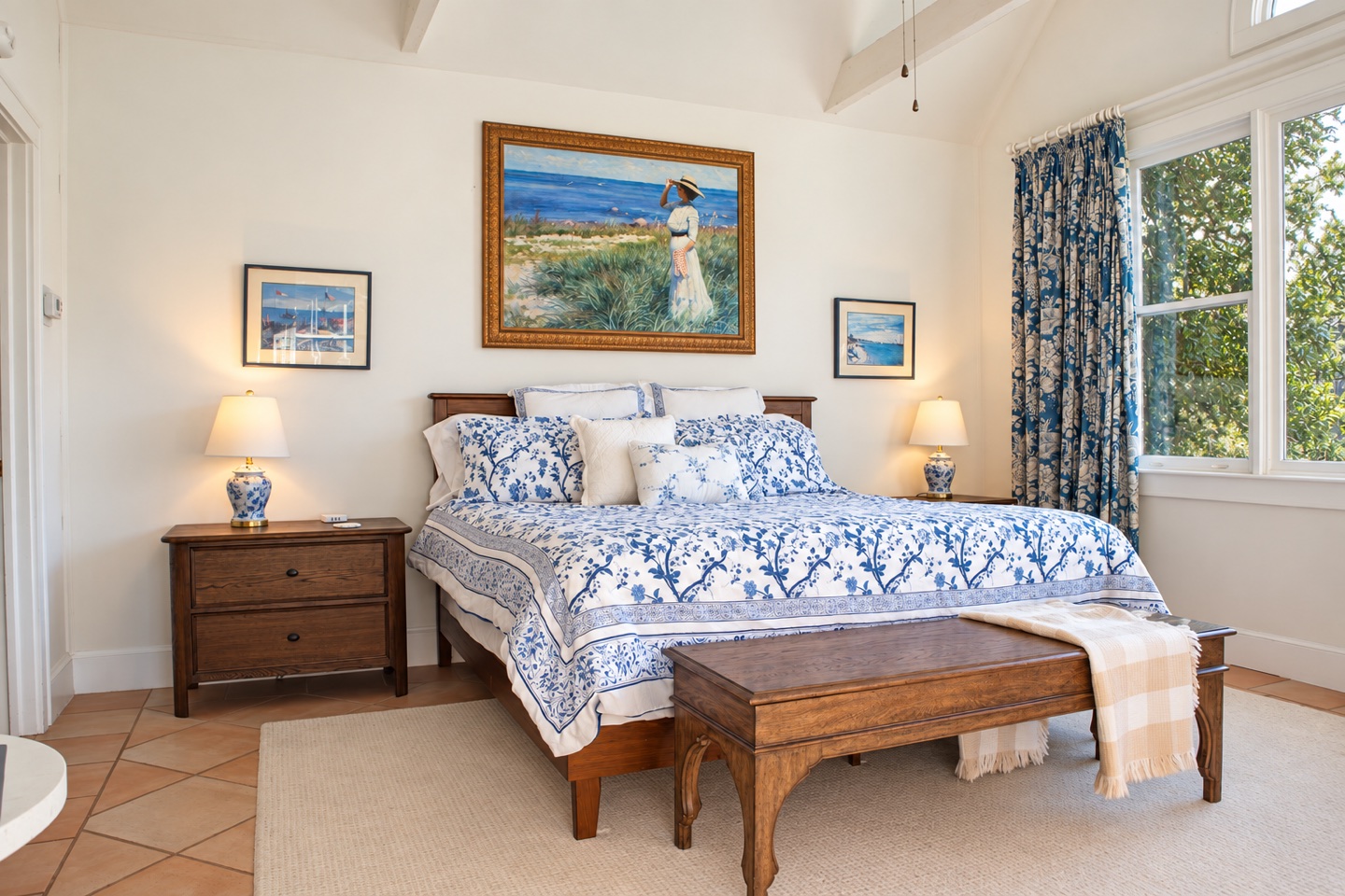 The Carriage House bedroom with a blue toile bed and bright windows overlooking the grounds