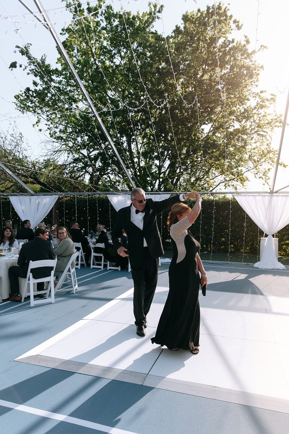 The wedding couple taking their first dance beneath the reception tent